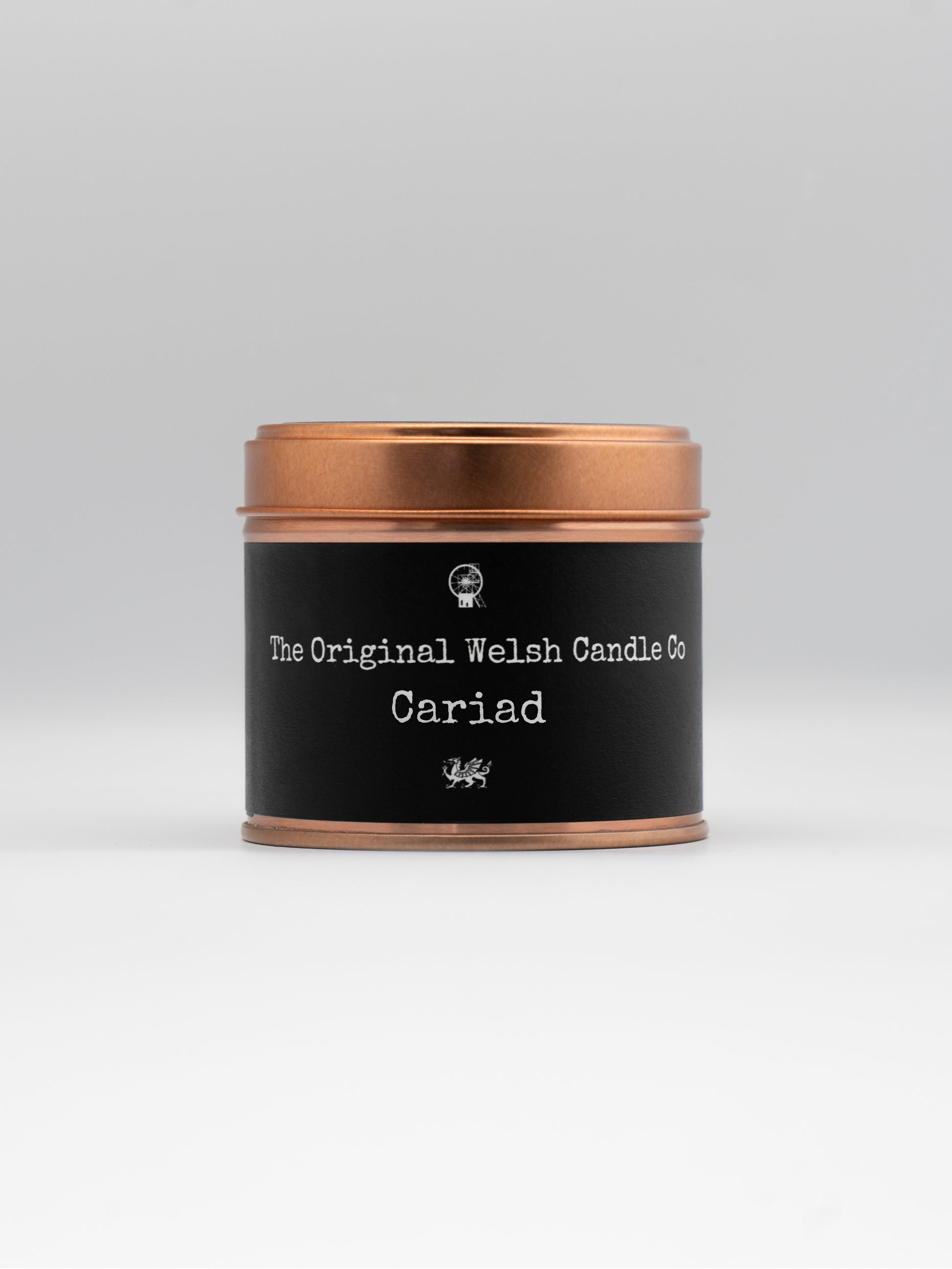  a copper tin with a black label saying CARIAD the welsh word for sweetheart, contains a scented candle with black pomegranate fragrance