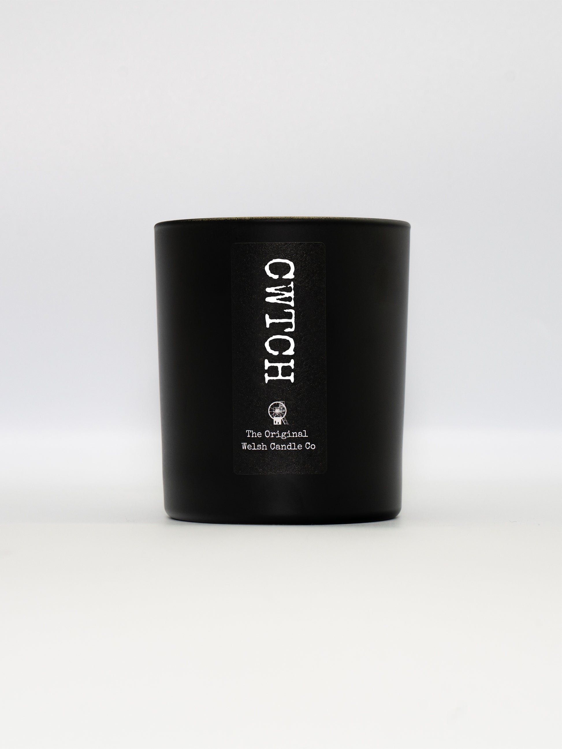 A luxury matt black glass jar, containing a soy scnted candle fragranced with rose and oud